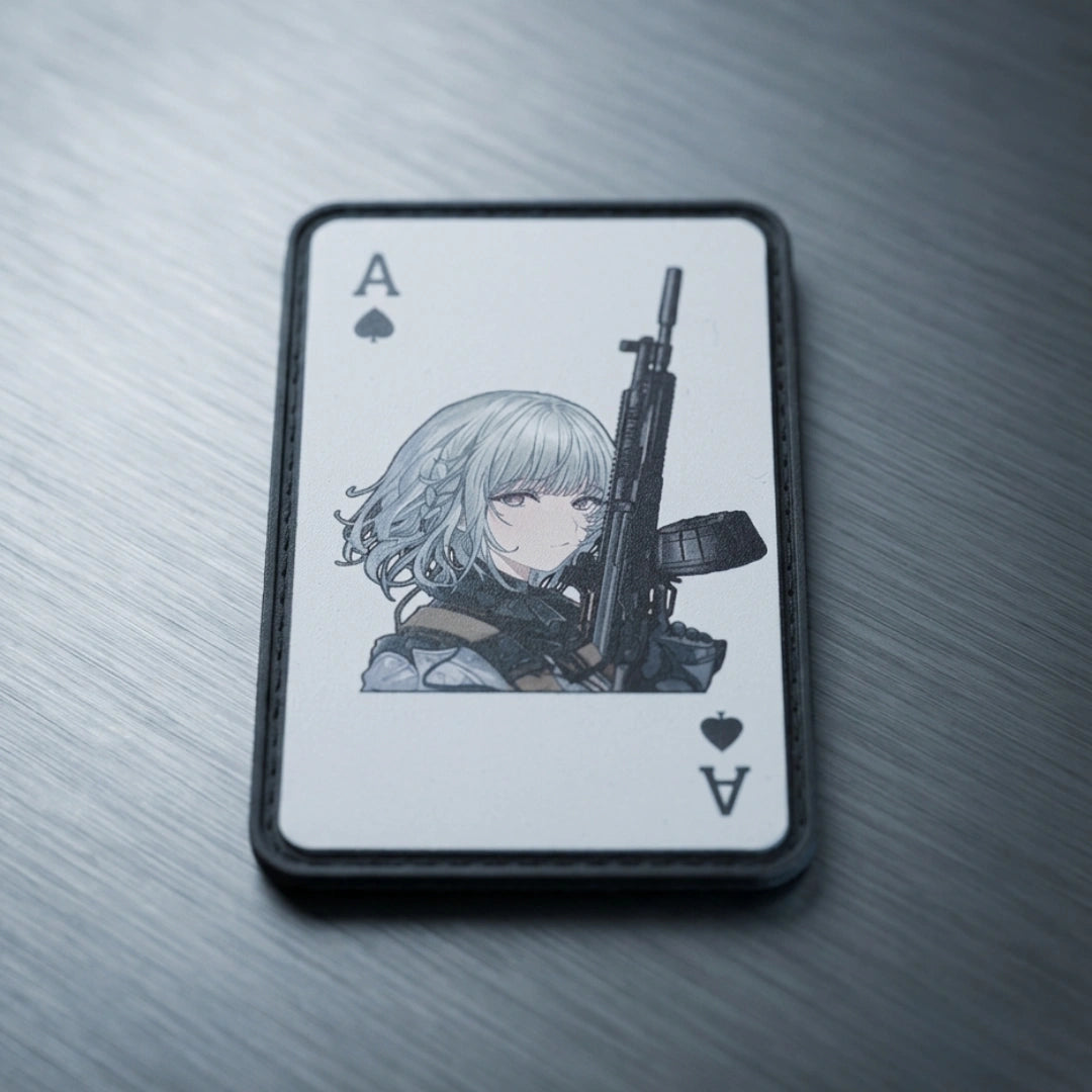 An Ace of Spades playing card featuring an anime-style illustration of a girl with silver hair holding a rifle, resting on a brushed metal surface.