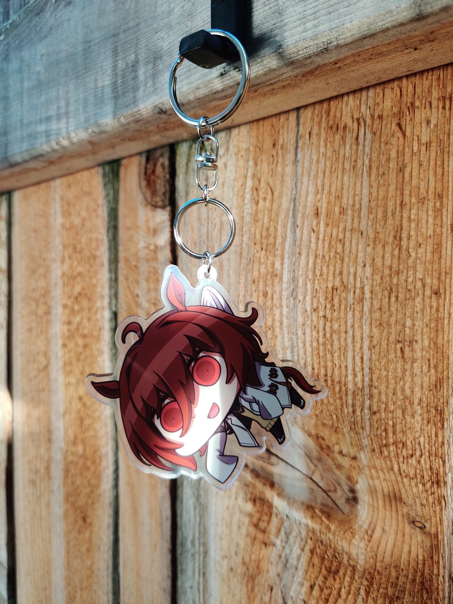 Keychain with anime-style character Agnes_Tachyon on a wooden surface