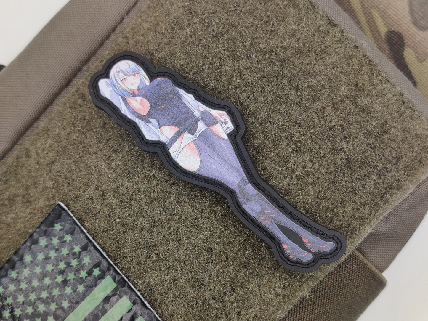 Lucy from Cyberpink: Edgerunners on a tactical pouch with a camouflage background