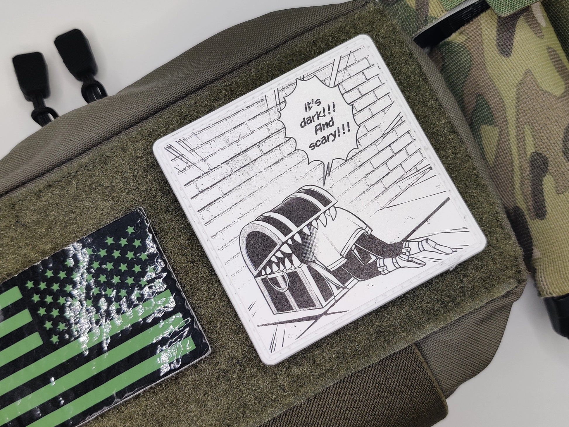 Green bag with a cartoon patch and American flag patch on a white background