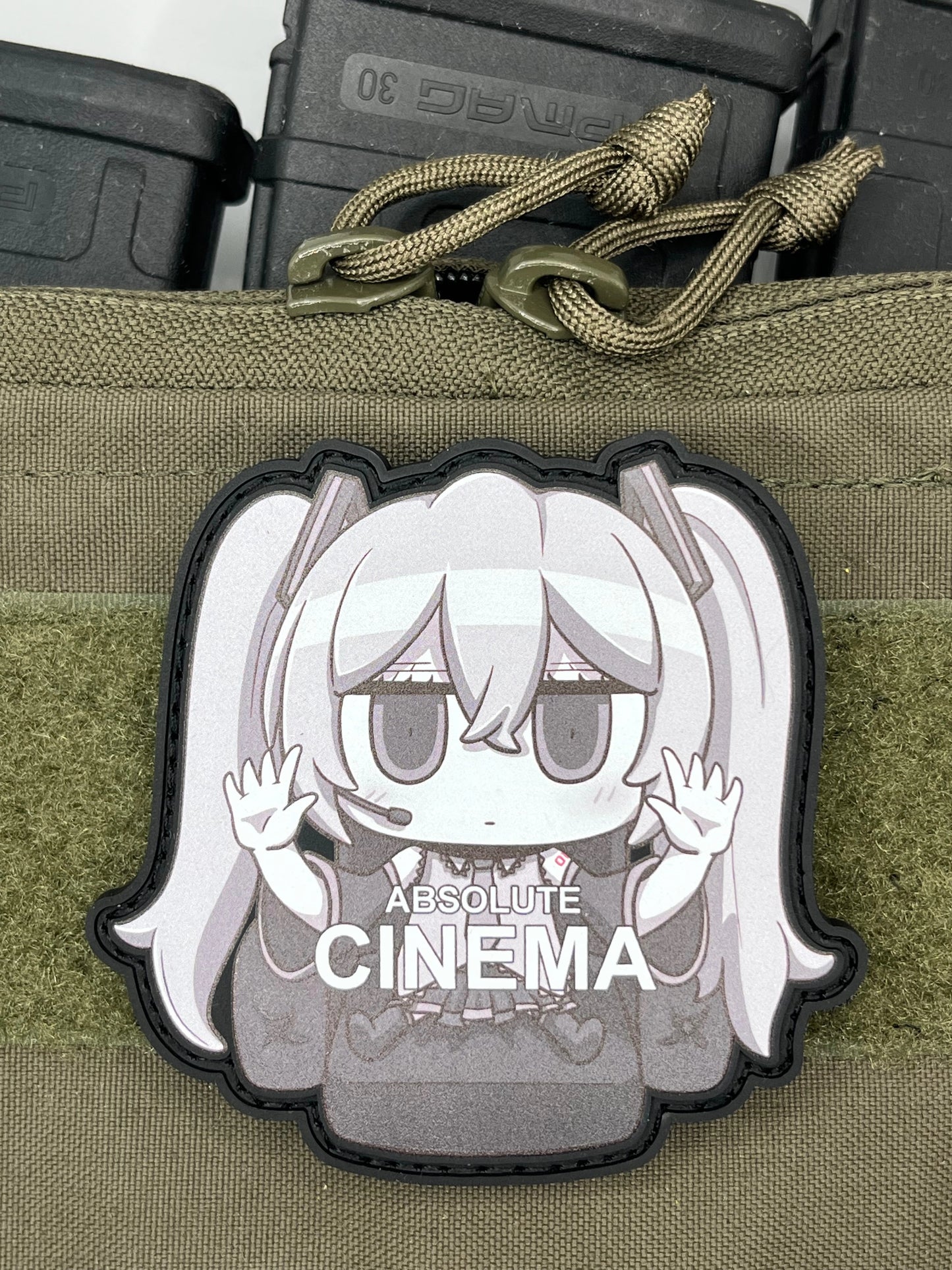 Anime character Hatsune_Miku patch on a green tactical pouch with 'Absolute Cinema' branding.