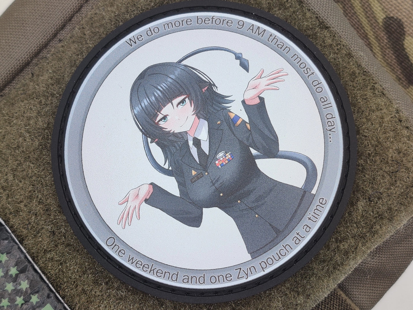 Circular patch of Jane Done from zenless zone zero with the text we do more before 9AM than most do all day one weekend and one Zyn pouch at a time on a texture surface