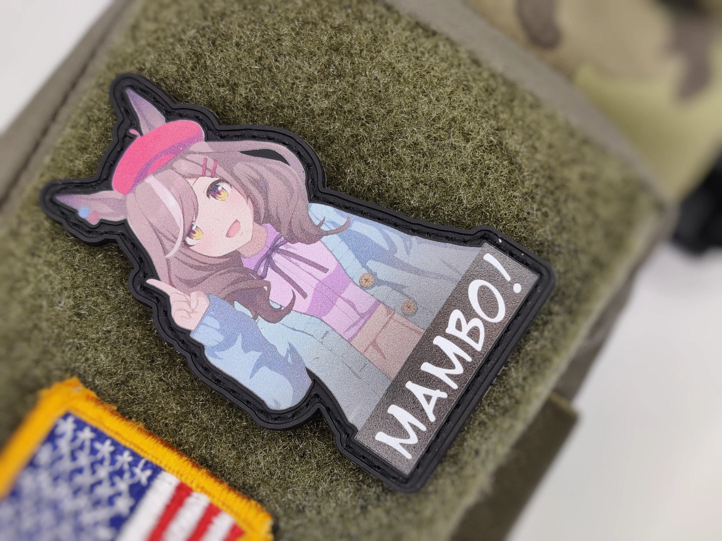 Anime-style character patch with 'MAMBO!' text at the bottom on a textured surface