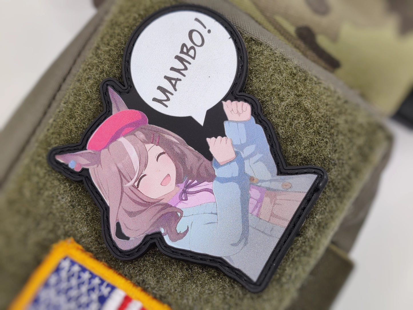 Anime-style character patch with 'MAMBO!' text on the right side on a green texture background