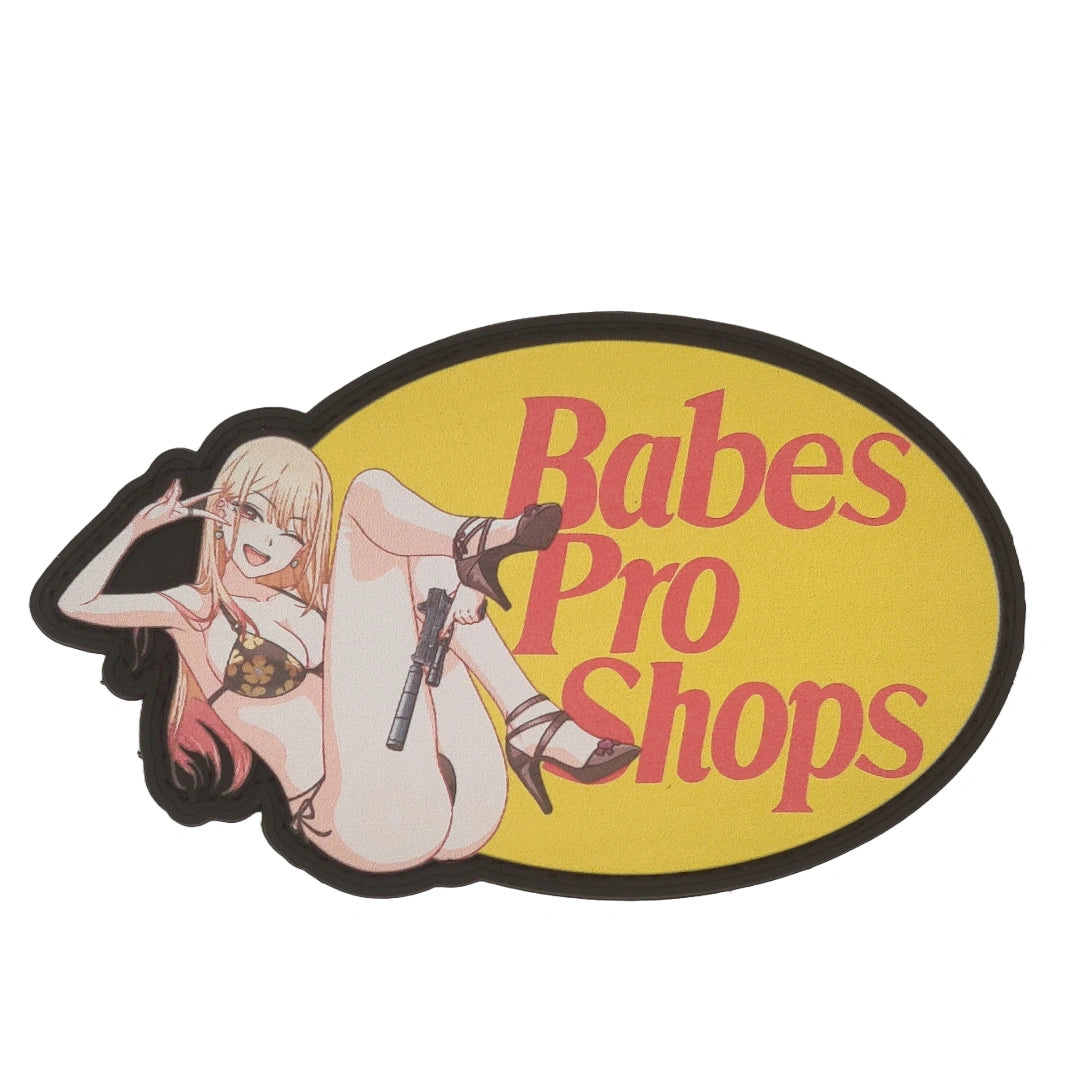 Sticker with 'Babes Pro Shops' text and a stylized illustration of a woman holding a gun on a yellow background.