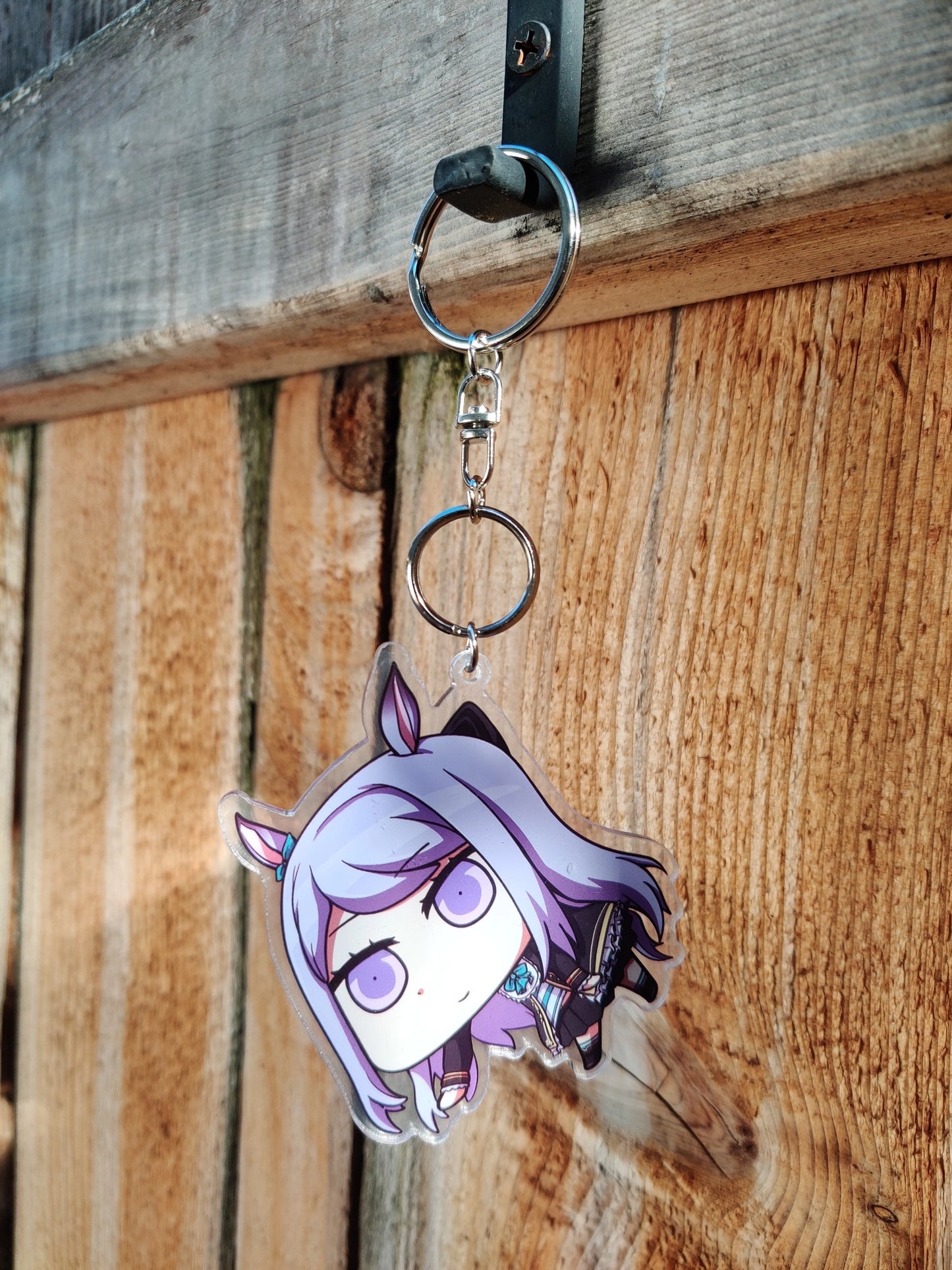 Keychain Mejiro_McQueen from uma musume on a wooden background