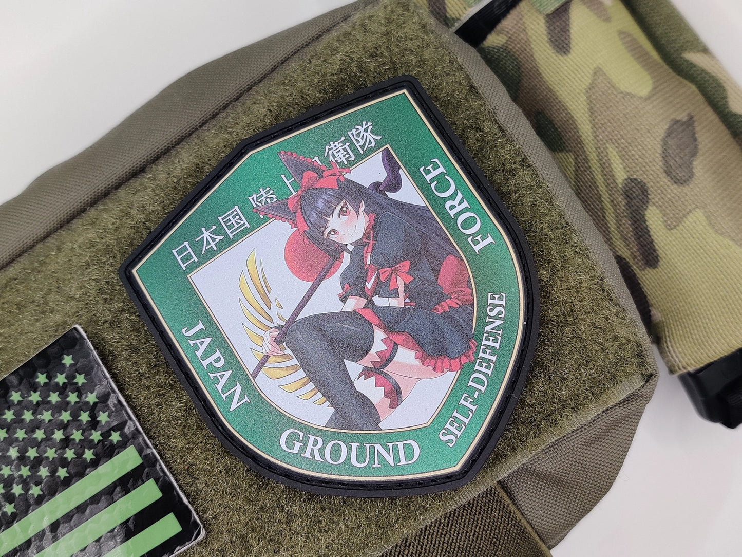 Japan Ground Self-Defense Force patch on a green surface with camouflage background