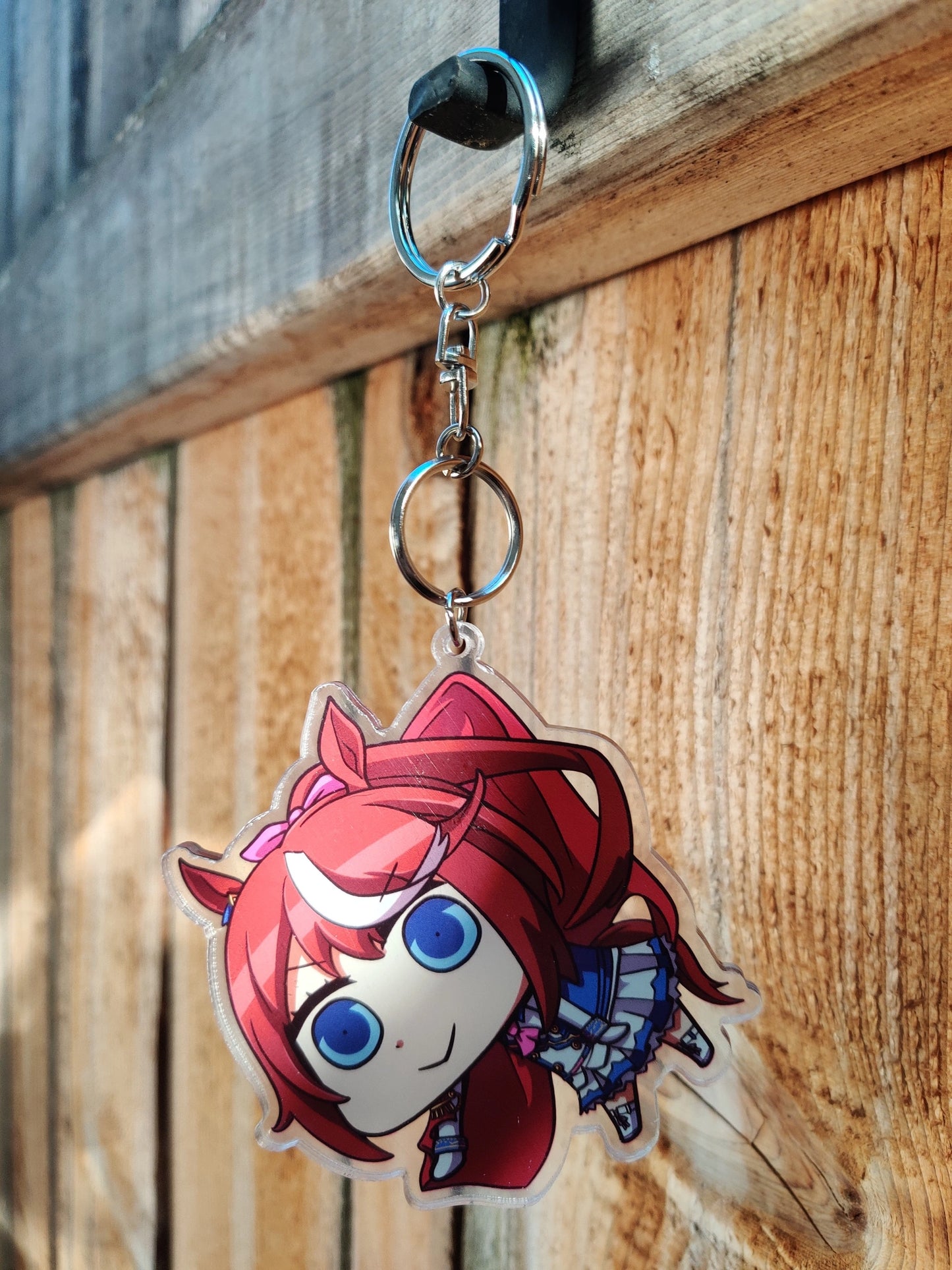 Anime character of Tokai Teio from Uma Musume with red hair and blue eyes on a wooden background
