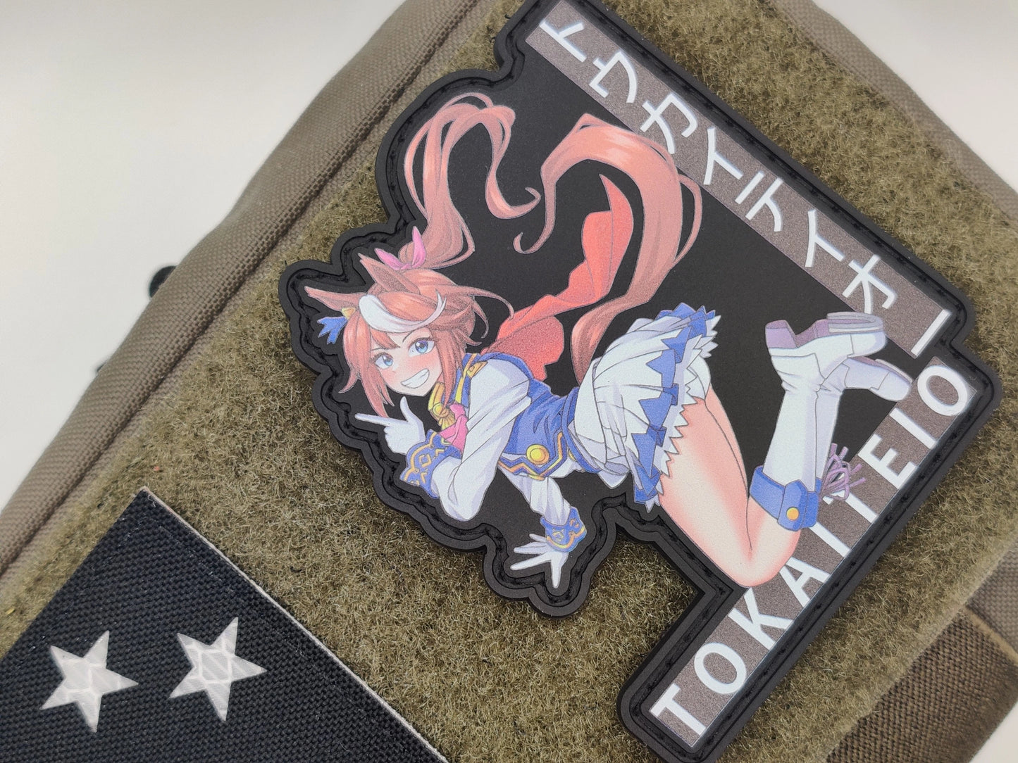 Tokai Teio jumping with her legs up 'TOKAITEIO' text on a green texture background