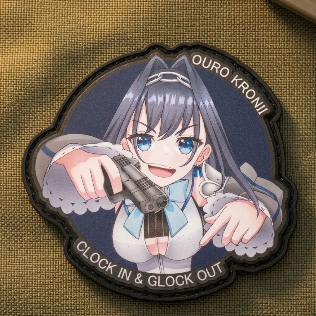 Ouro Kronii "Clock In & Glock Out" patch on yellow-tan tactical canvas fabric, displaying Warden of Time character with pistols and embroidered velcro backing detail