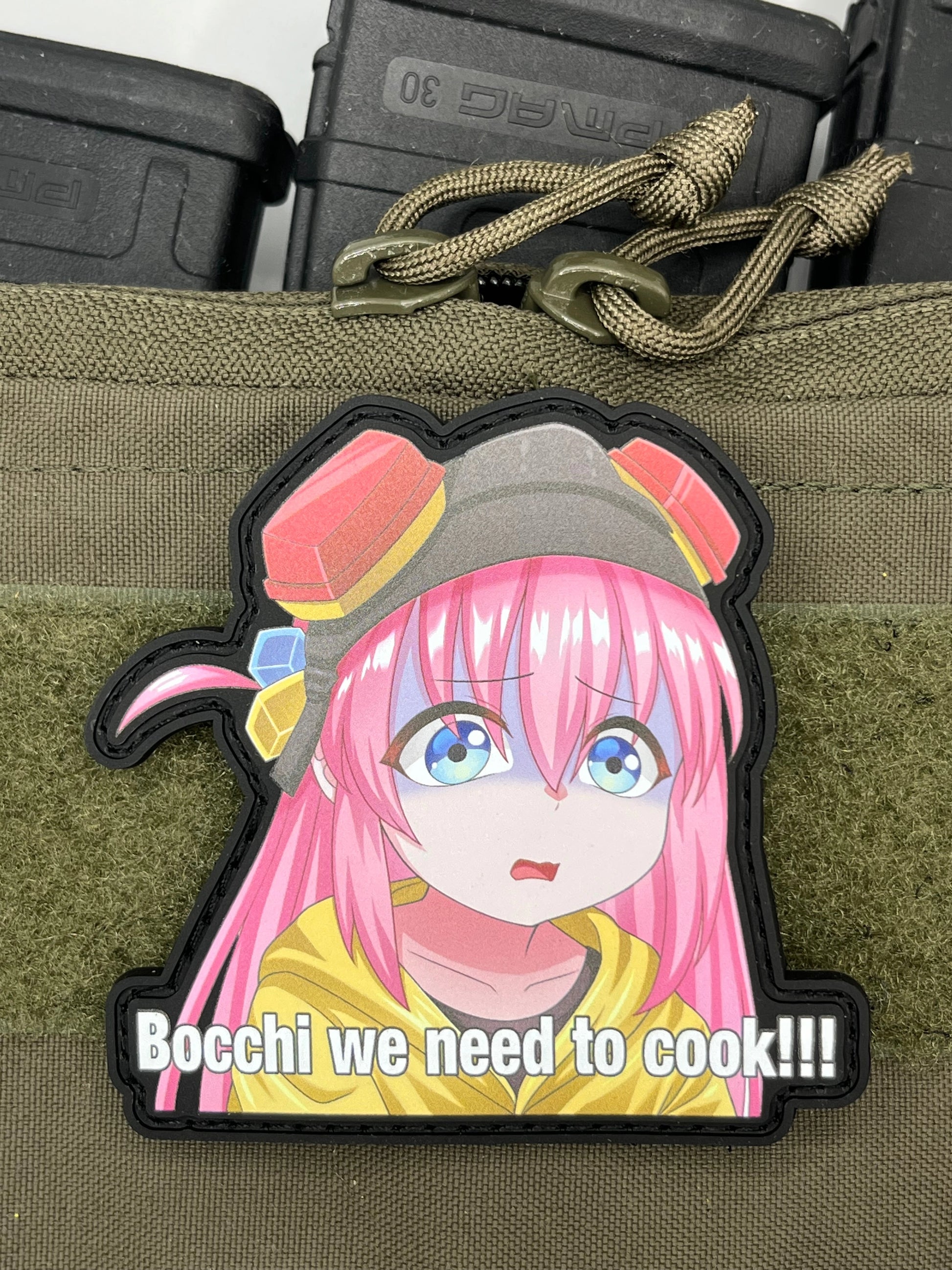 Anime character with pink hair and a yellow outfit on a black background with text 'Bocchi we need to cook!!'.