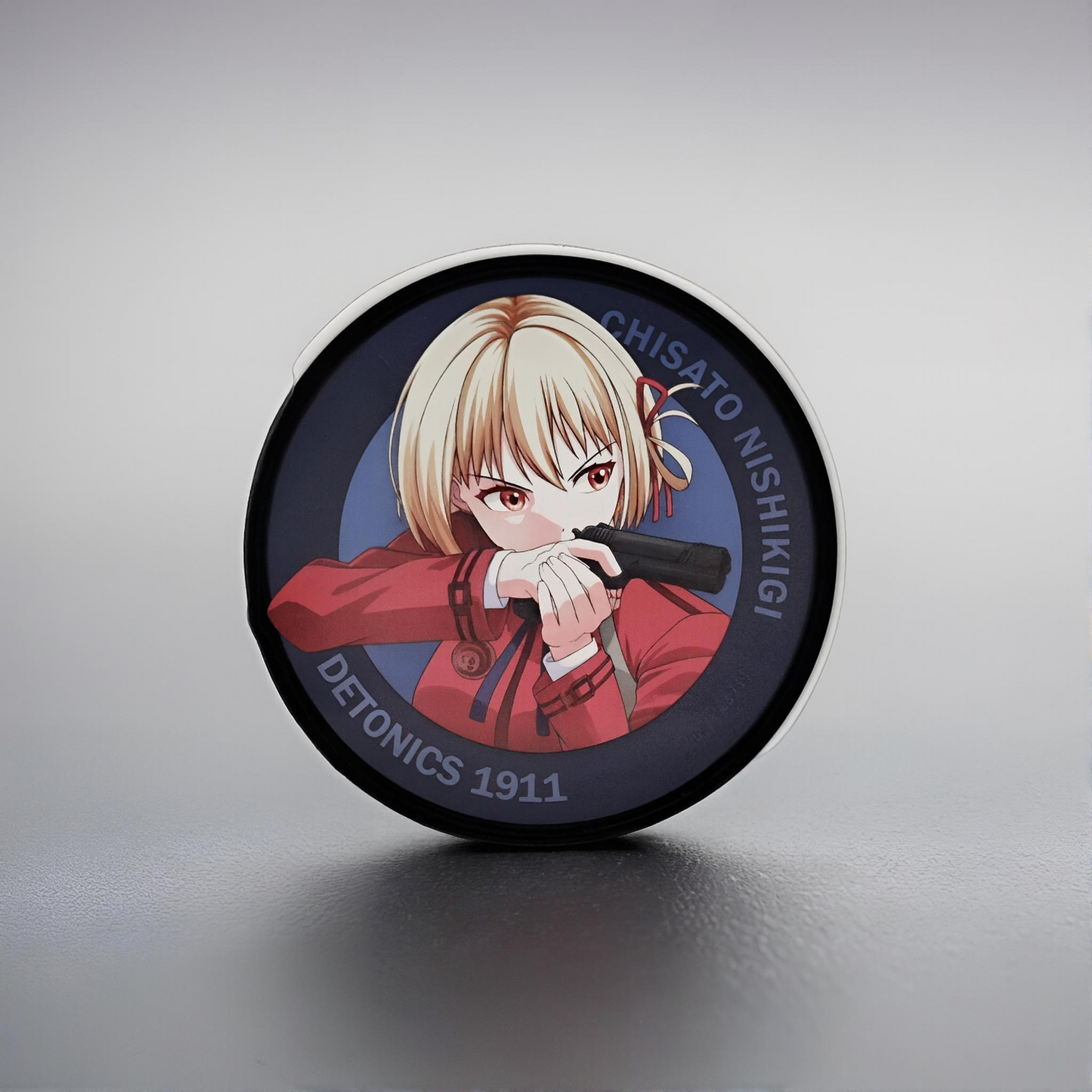 Circular product with illustration of Chisato Nishikigi from Lycoris Recoil on a gray background