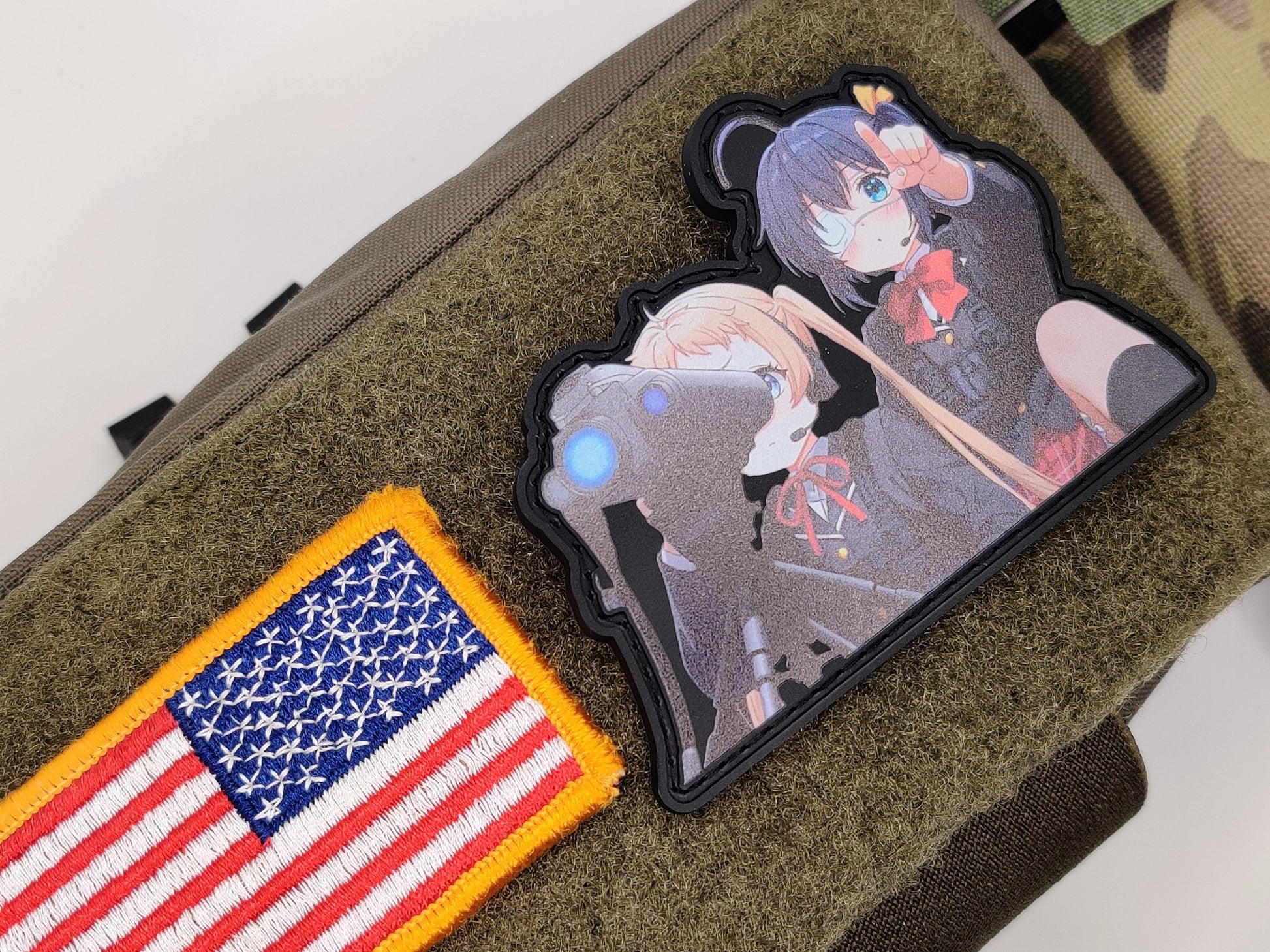 Chunibyo Forward Observer Patch  - Love, Chunibyo & Other Delusions on a green surface, one with an American flag design and the other featuring an anime character.