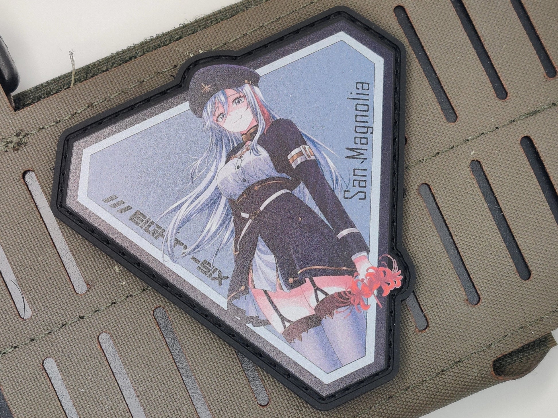 Patch of Lena Vladilena Miliz from the anime Eighty Six holding a Red Spider Lily with one hand on a green background