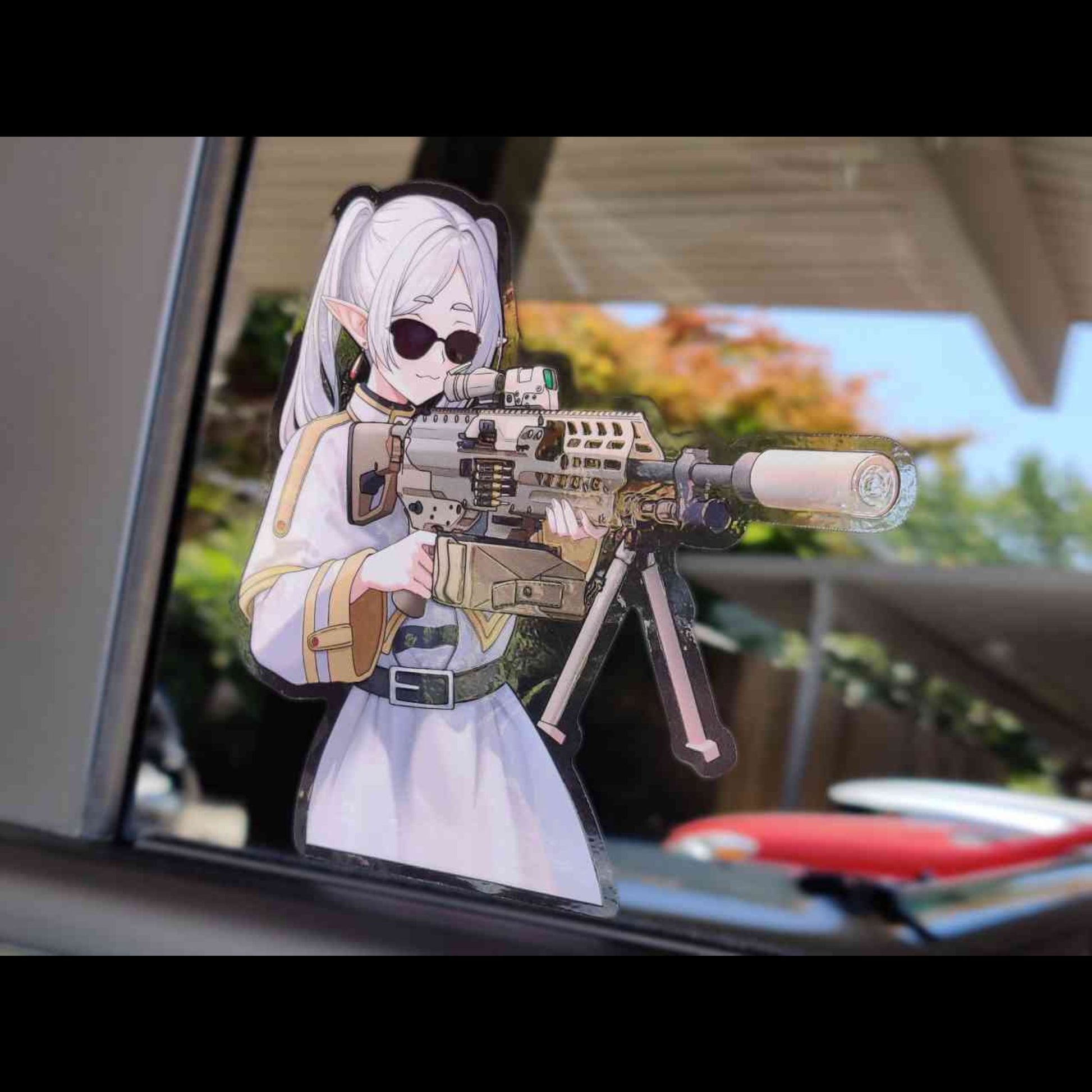 A custom made sticker featuring Frieren from the anime Frieren: Beyond the Journey's end holding the XM250 blasting through the demonic's stronghold.