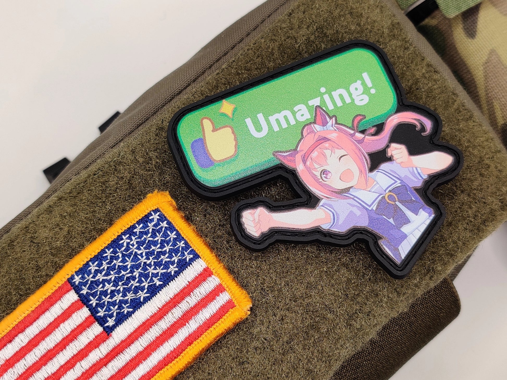 Haru Urara Umazing Patch on a green surface, one with an American flag and the other with Haru Urara and 'Umazing!' text.