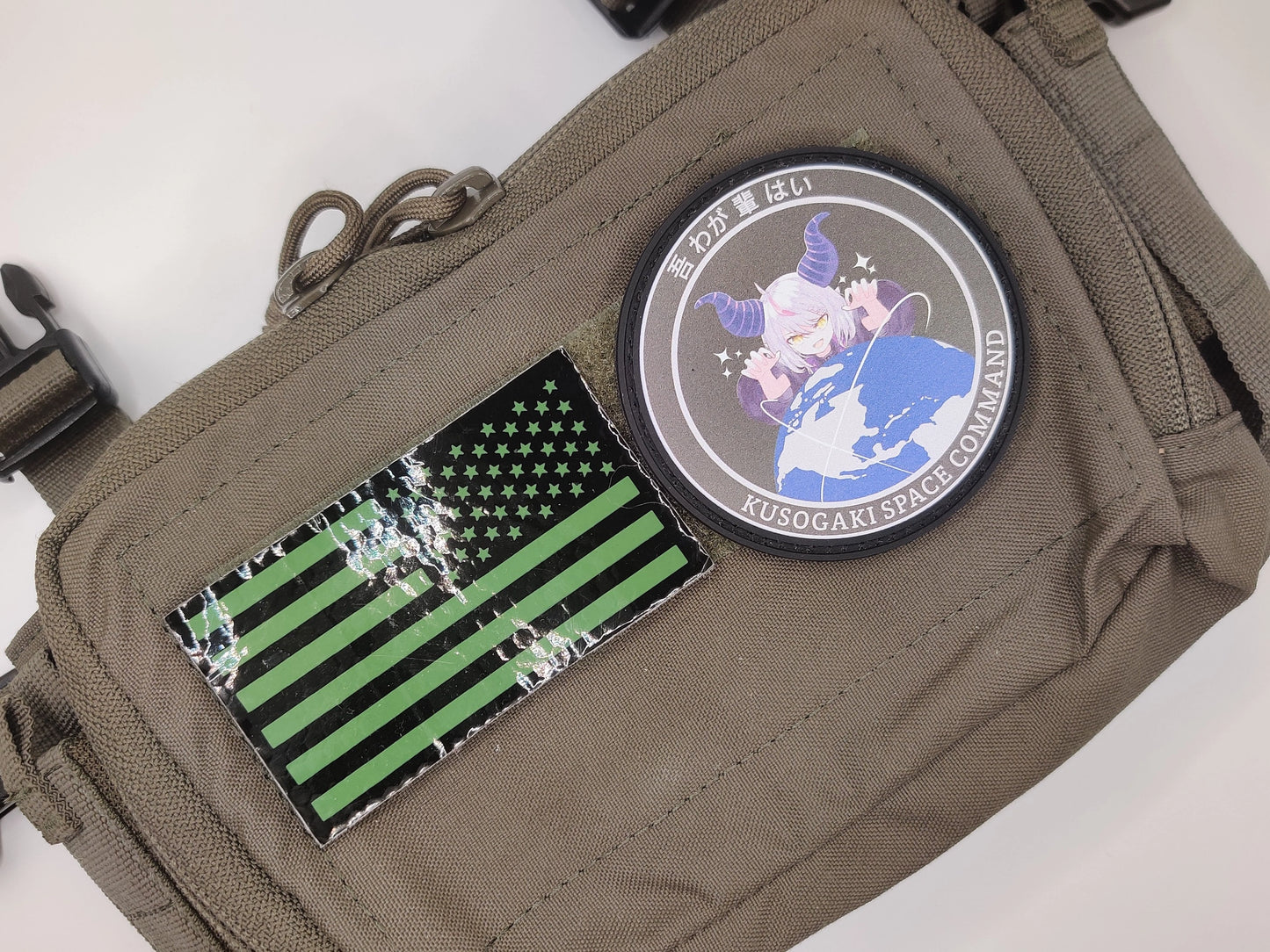 Brown pouch with patches including a green and black flag and a character patch on a white background