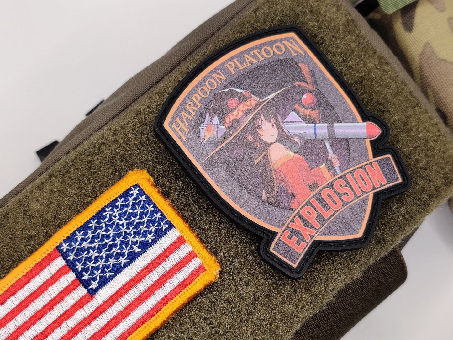Megumin Harpoon Platoon Patch on a green fabric background, one with an American flag design and the other with a Megumi and the text harpoon platoon explosion AGM 84