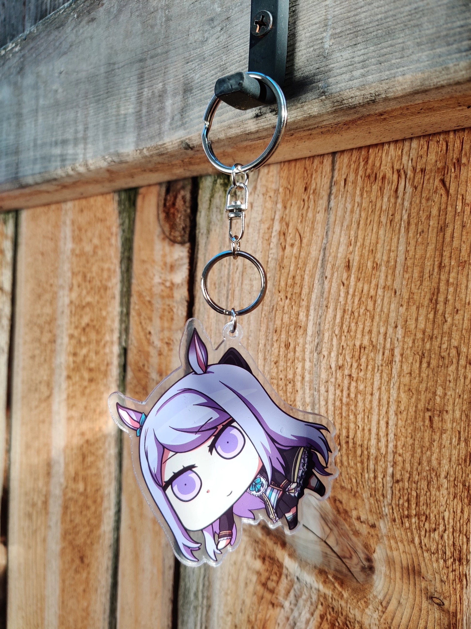 Keychain Mejiro_McQueen from uma musume on a wooden background