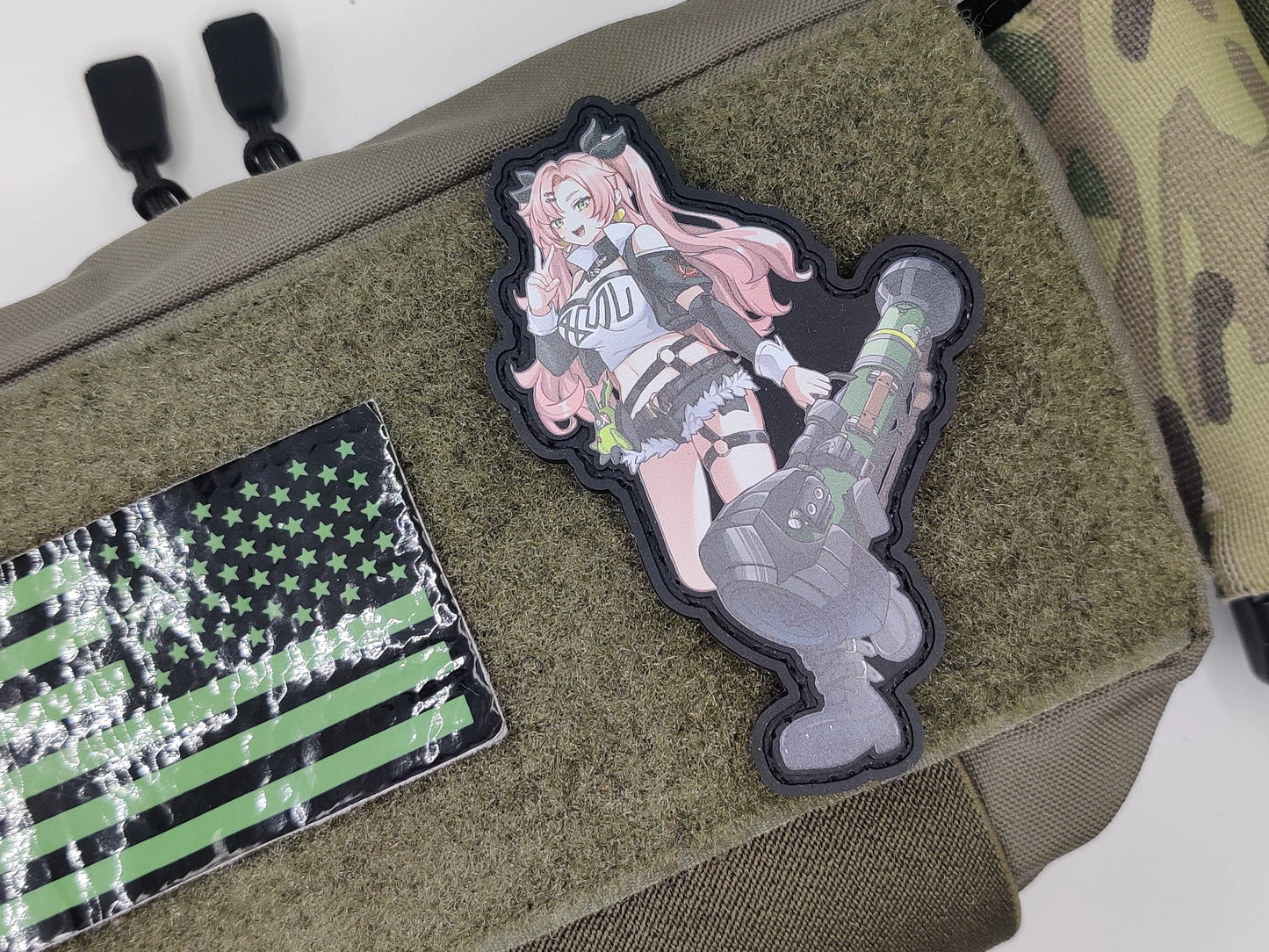 Two patches on a green bag: one with a character design and another with an American flag.