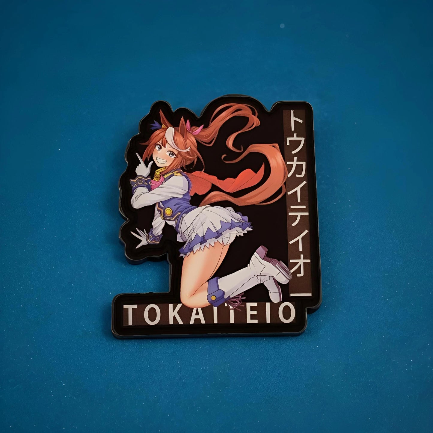 Sticker with anime character and 'TOKAITEIO' text on a blue background