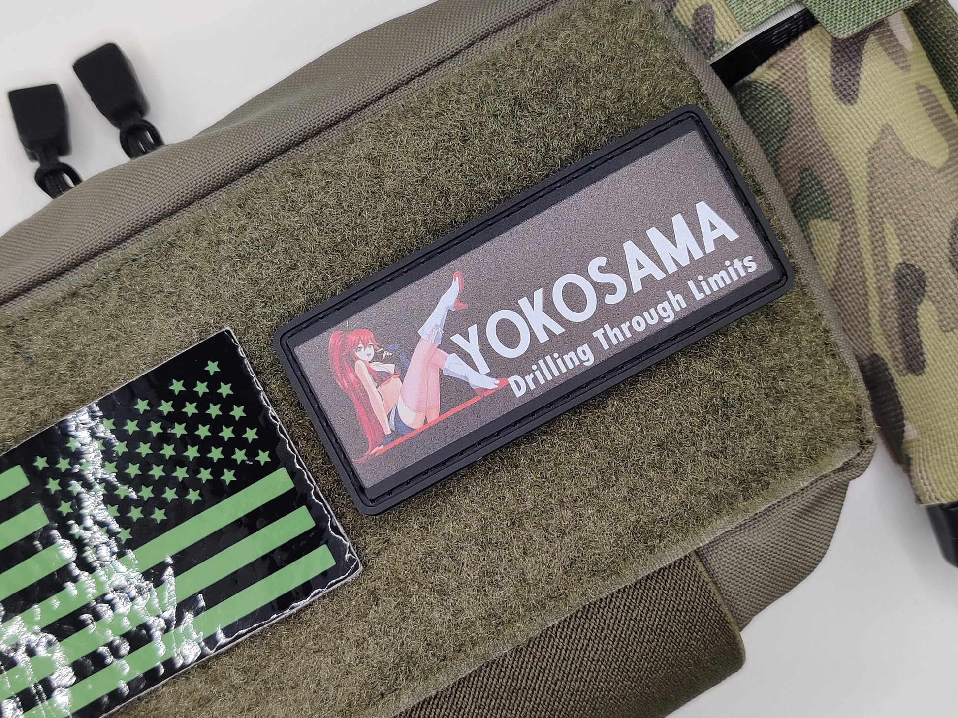 Green tactical pouch with patches including a flag and 'YOKOSAMA' branding.