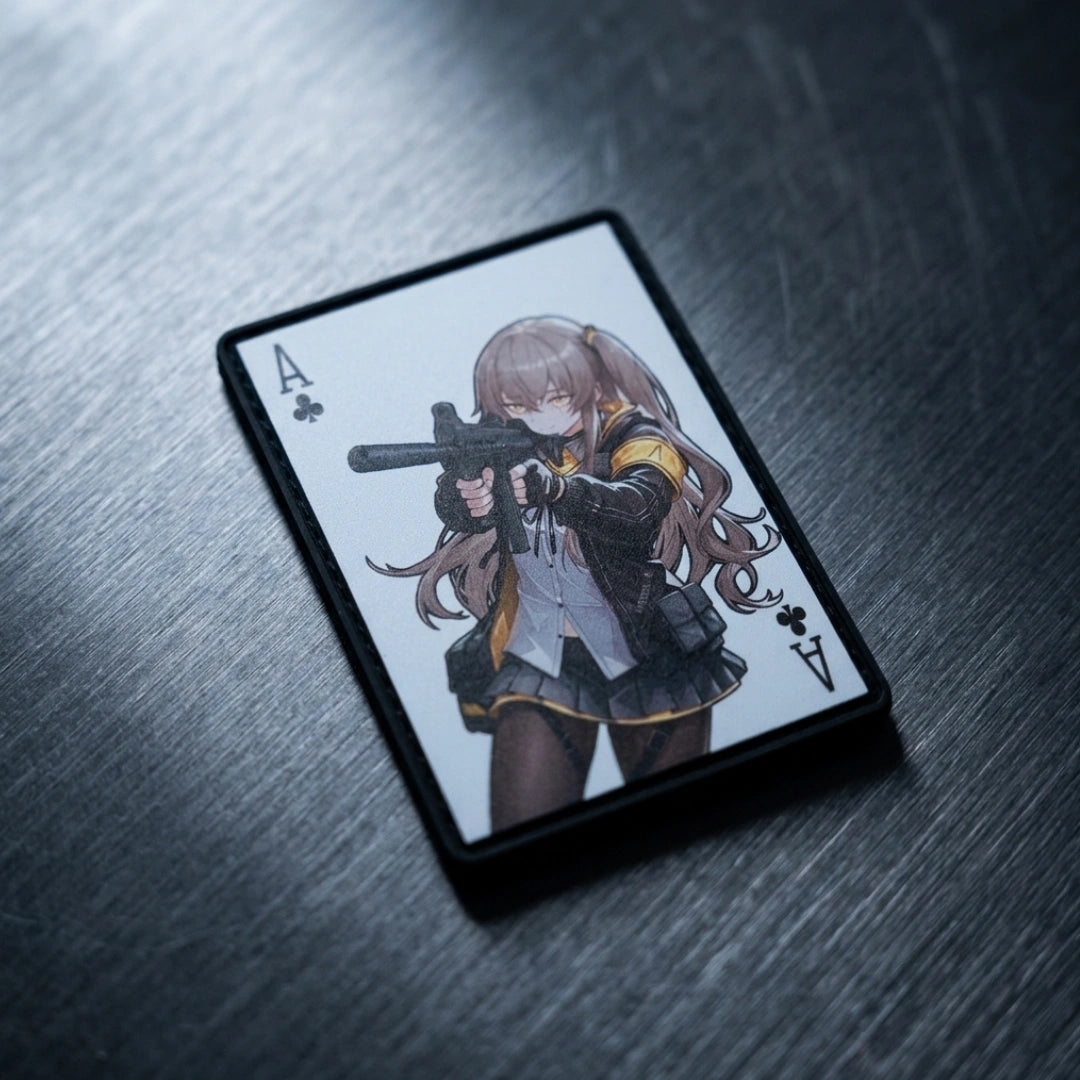 An Ace of Clubs playing card featuring an anime-style illustration of a girl aiming a gun, resting on a dark, brushed metal surface.